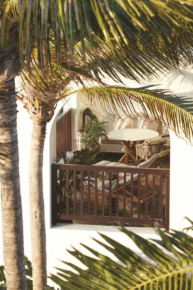 Palm-framed balcony with outdoor seating at Cap Juluca, Anguilla.
