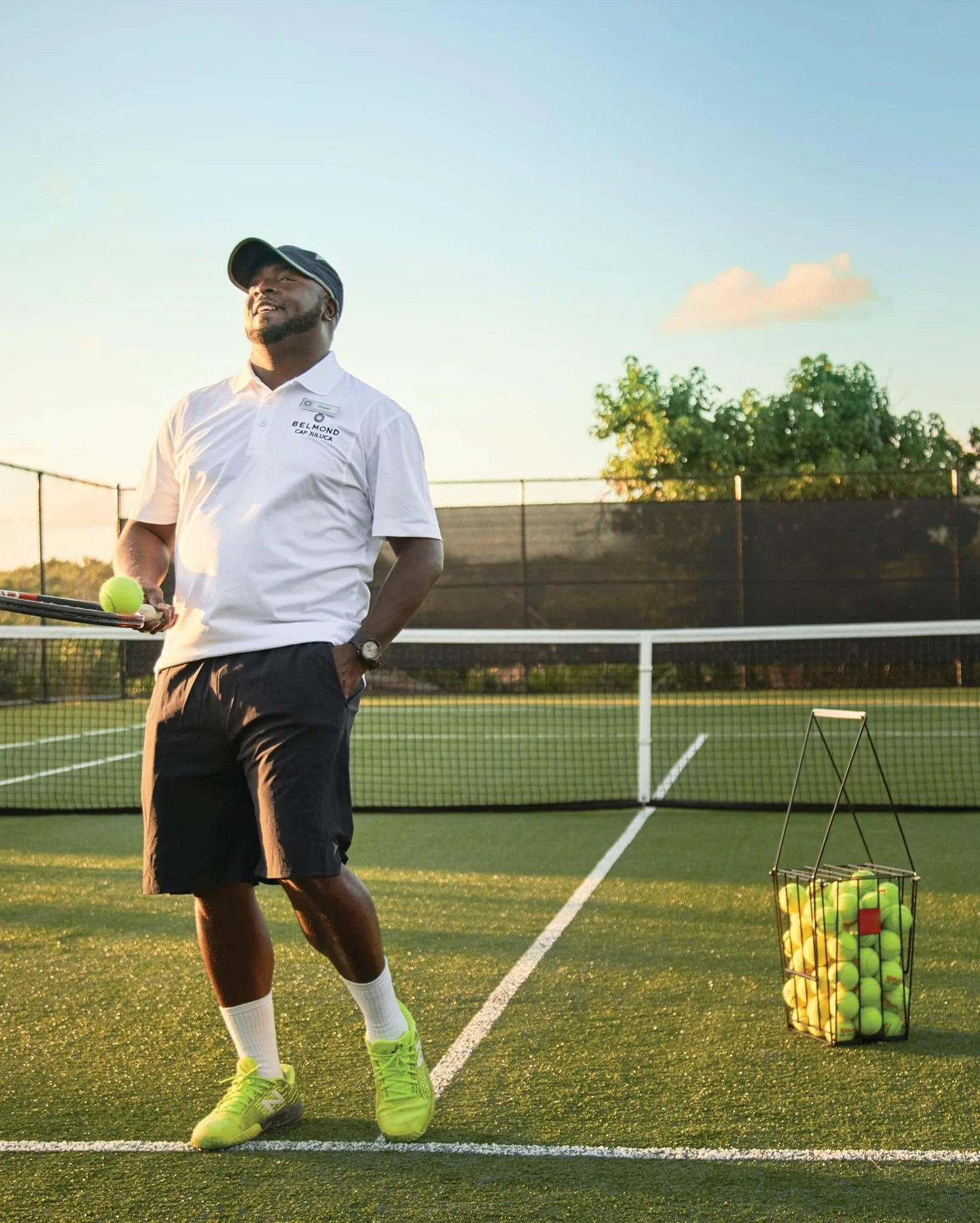 Tennis coach with rackets and balls on the court at Cap Juluca, Anguilla.
