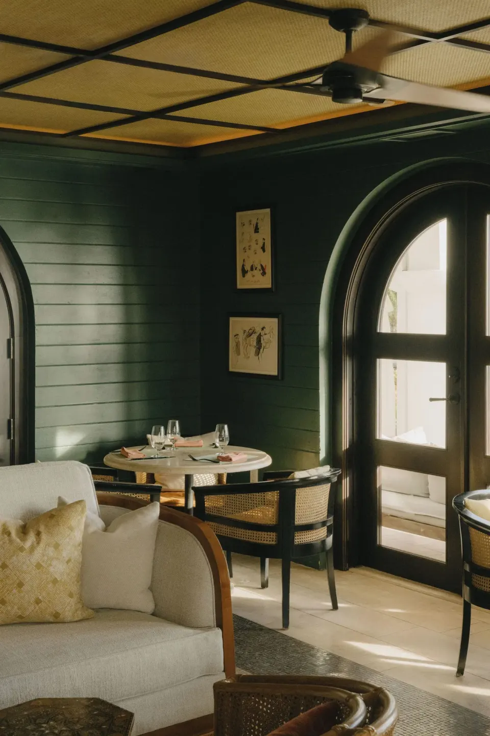 Intimate dining room with dark green walls and arched doors at Cap Juluca, Anguilla.