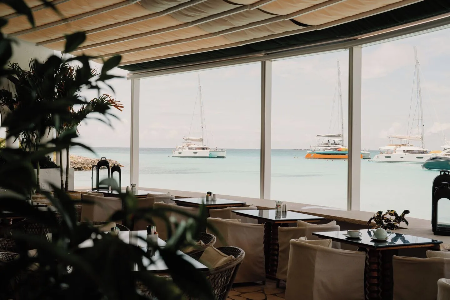 Seaside dining room with catamarans visible through large windows at Cap Juluca, Anguilla.