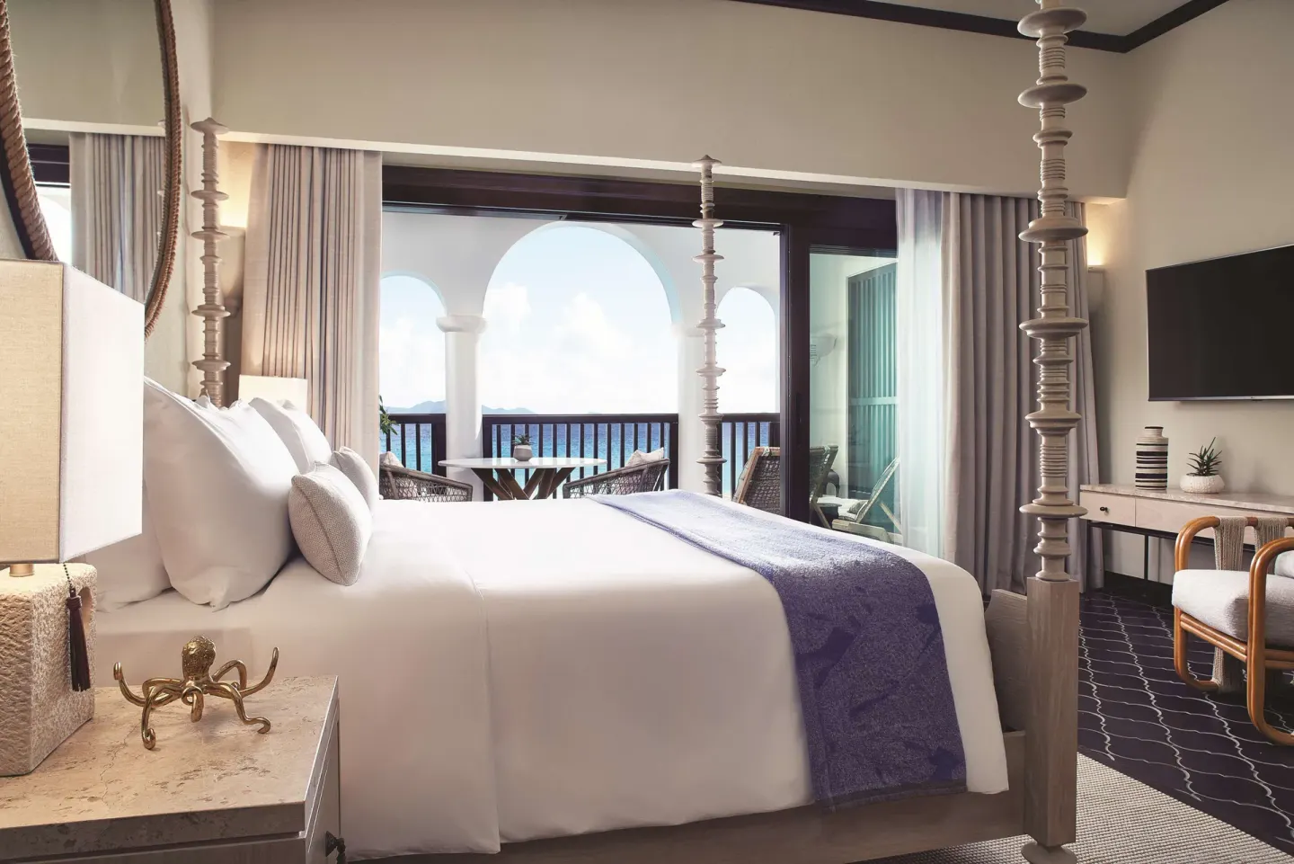 Beachfront One Bedroom Pool Suite bedroom with four-poster bed and balcony at Cap Juluca, Anguilla.