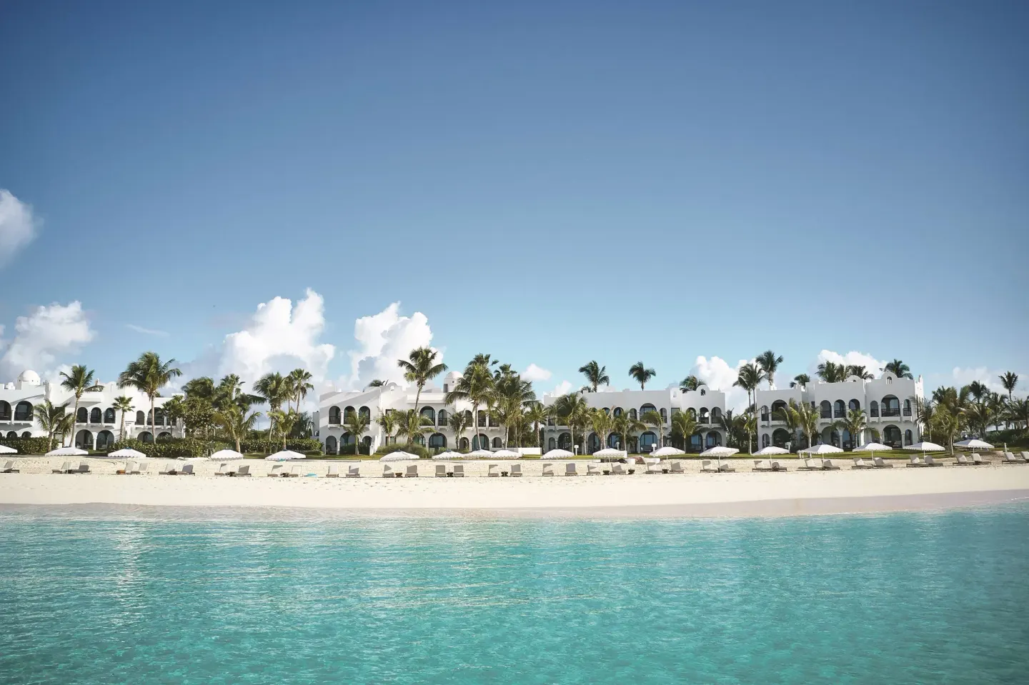 Beachfront One Bedroom Suite buildings and beach at Cap Juluca, Anguilla, seen from turquoise water.