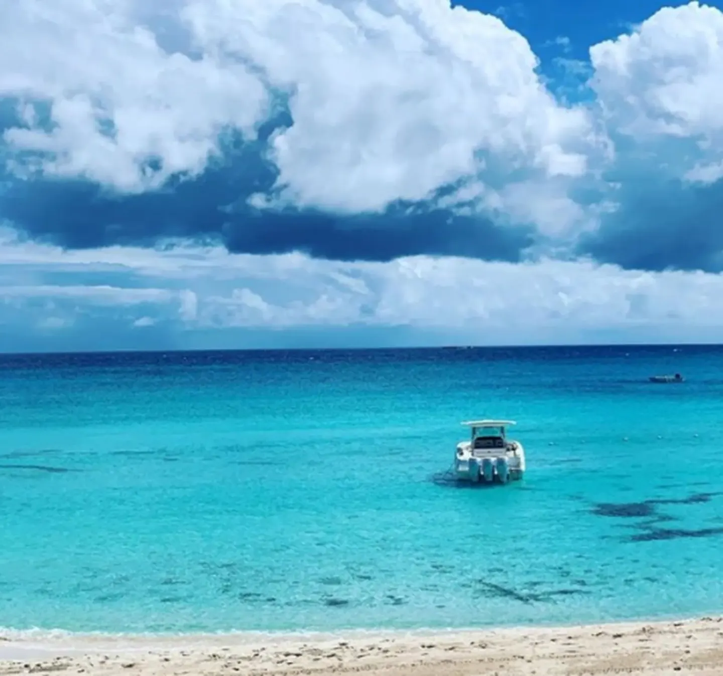 Turquoise beachfront water with small boats outside a Deluxe Room at Cap Juluca, Anguilla.