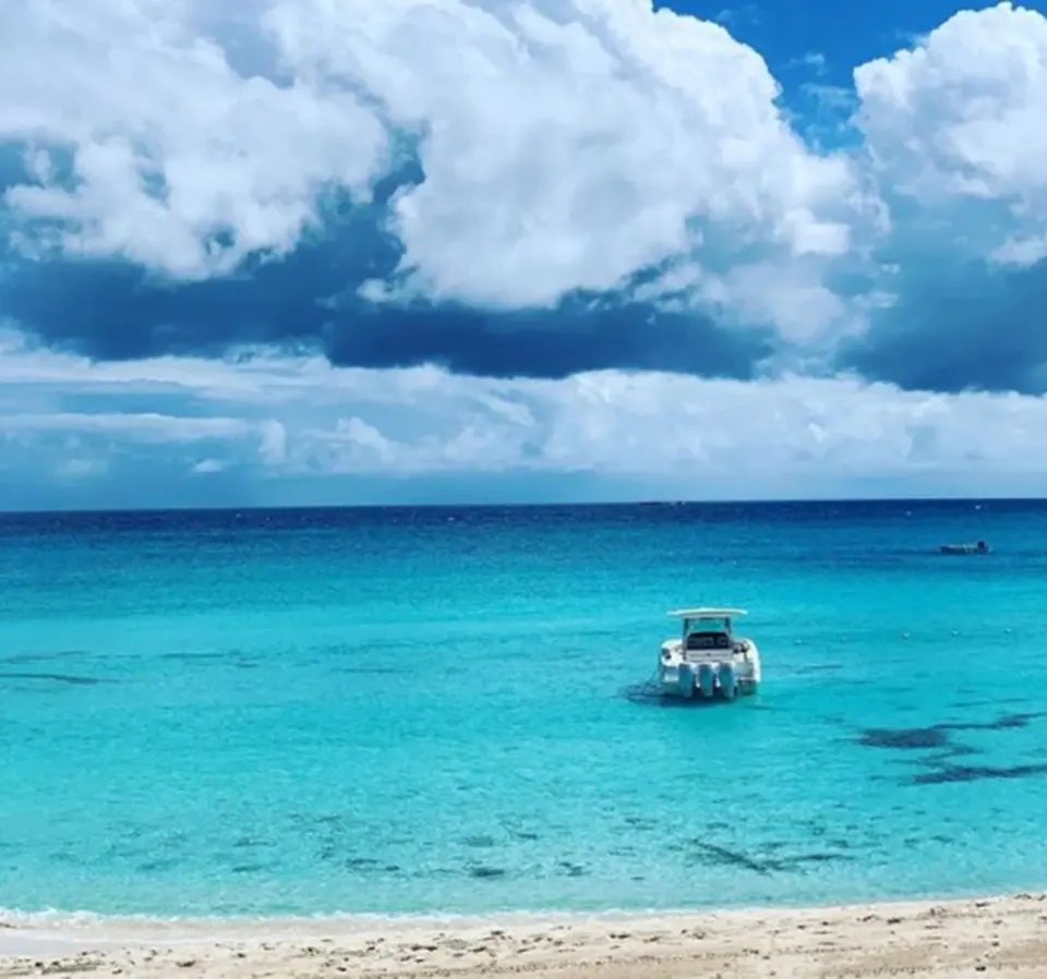 Turquoise beachfront water with small boats outside a Deluxe Room at Cap Juluca, Anguilla.