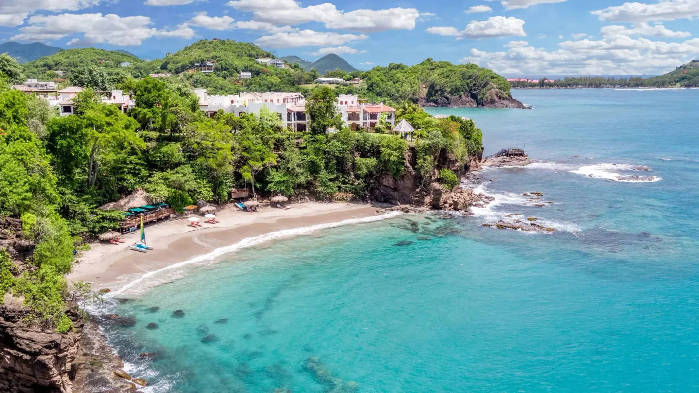 Aerial view of the beach and turquoise bay at Cap Maison Resort & Spa.