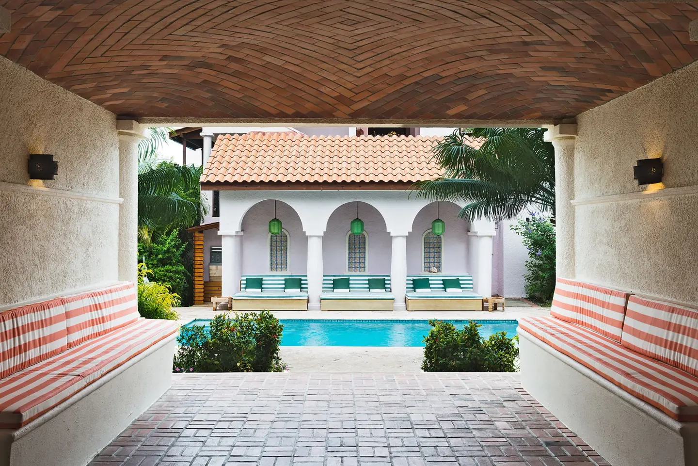 A covered walkway opens to a courtyard pool at Cap Maison Resort & Spa.