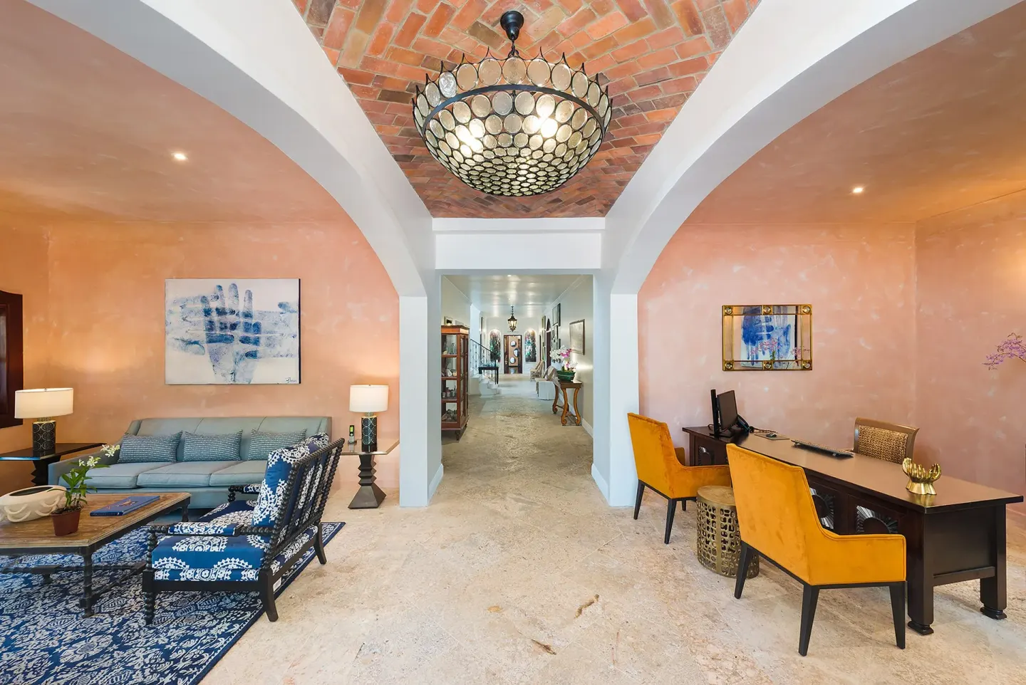 A peach-toned lobby lounge with desks and seating at Cap Maison Resort & Spa.