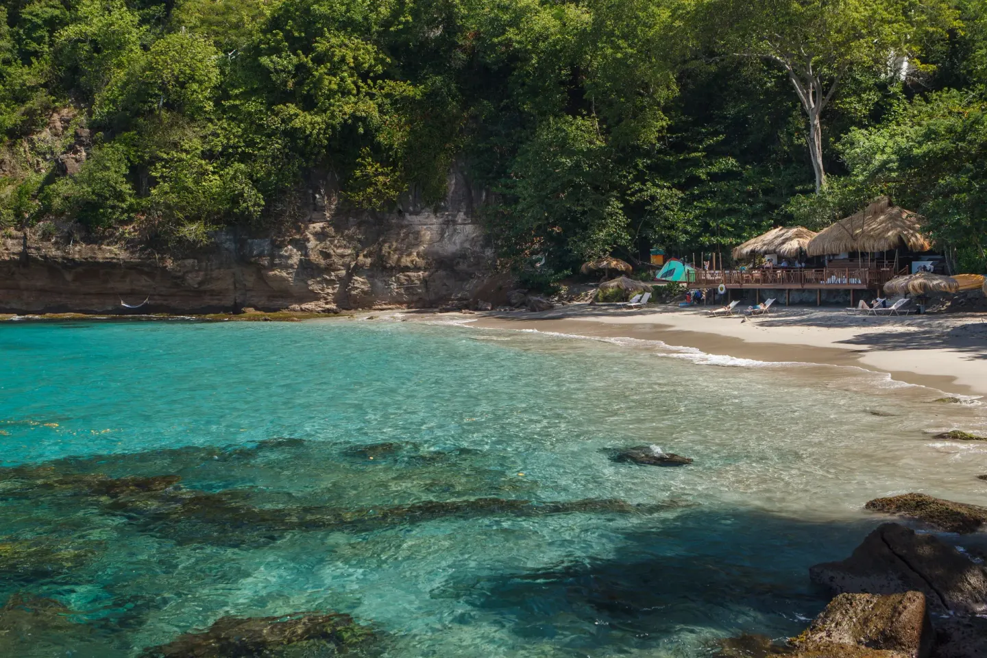Sandy cove with turquoise water and beach seating at Cap Maison Resort & Spa.