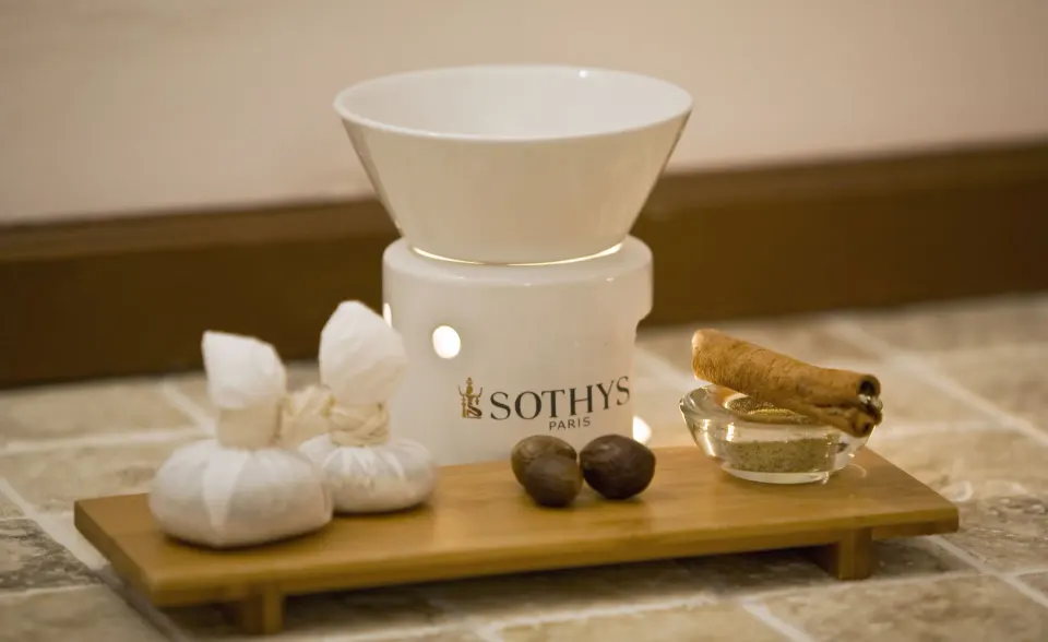 Spa aromatherapy setup with warmer, herbs, and stones at Cap Maison Resort & Spa.