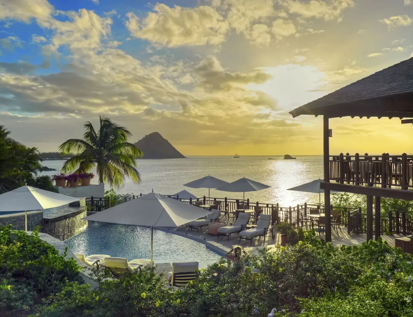 The pool terrace overlooks the sea at sunset at Cap Maison Resort & Spa.