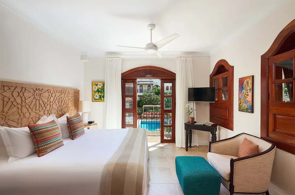 Garden View Room with king bed and balcony doors at Cap Maison Resort & Spa.