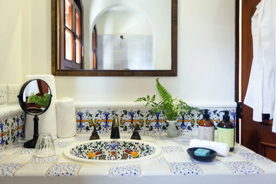 Junior Suite bathroom sink with colorful tilework and amenities at Cap Maison Resort & Spa.