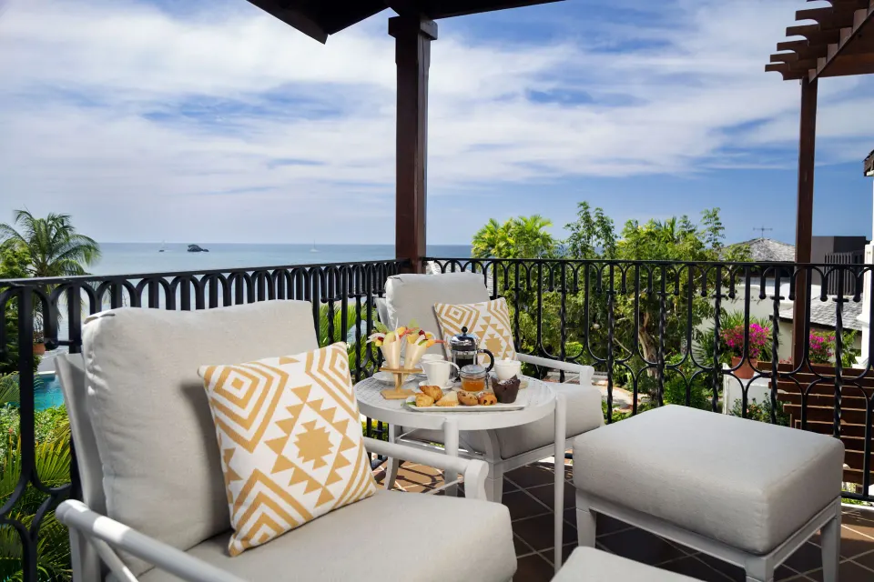 Junior Suite terrace seating with breakfast and sea views at Cap Maison Resort & Spa.