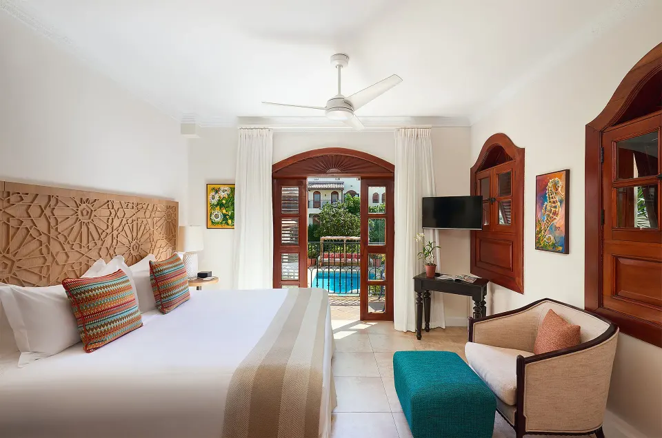 Garden View Room with king bed and balcony doors at Cap Maison Resort & Spa.
