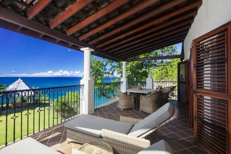 Ocean-view suite terrace with lounge seating and dining table at Cap Maison Resort & Spa.