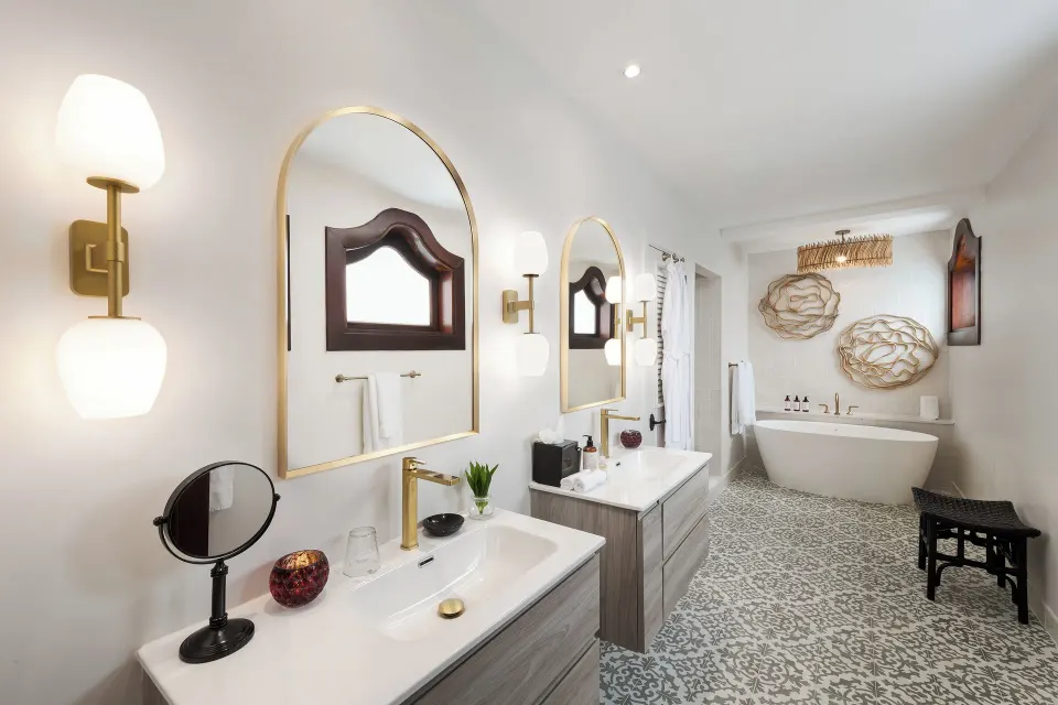Double vanity, freestanding tub, and patterned tile in a Spanish Courtyard suite at Cap Maison Resort & Spa.