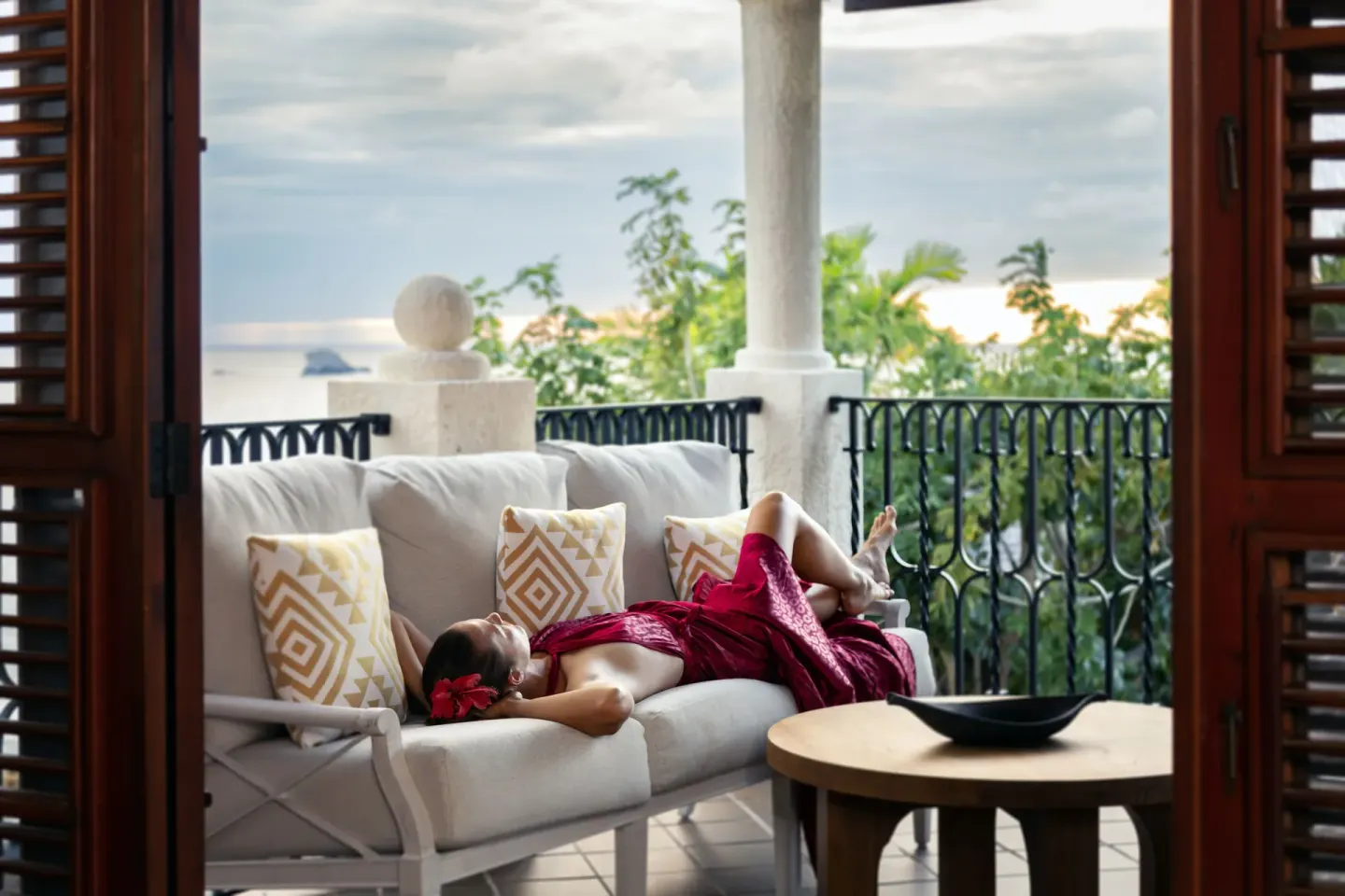 Guest reclining on a covered villa balcony with sea view at Cap Maison Resort & Spa.