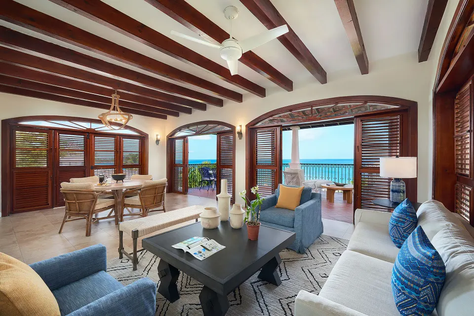 Villa living and dining room with open shutters and sea views at Cap Maison Resort & Spa.