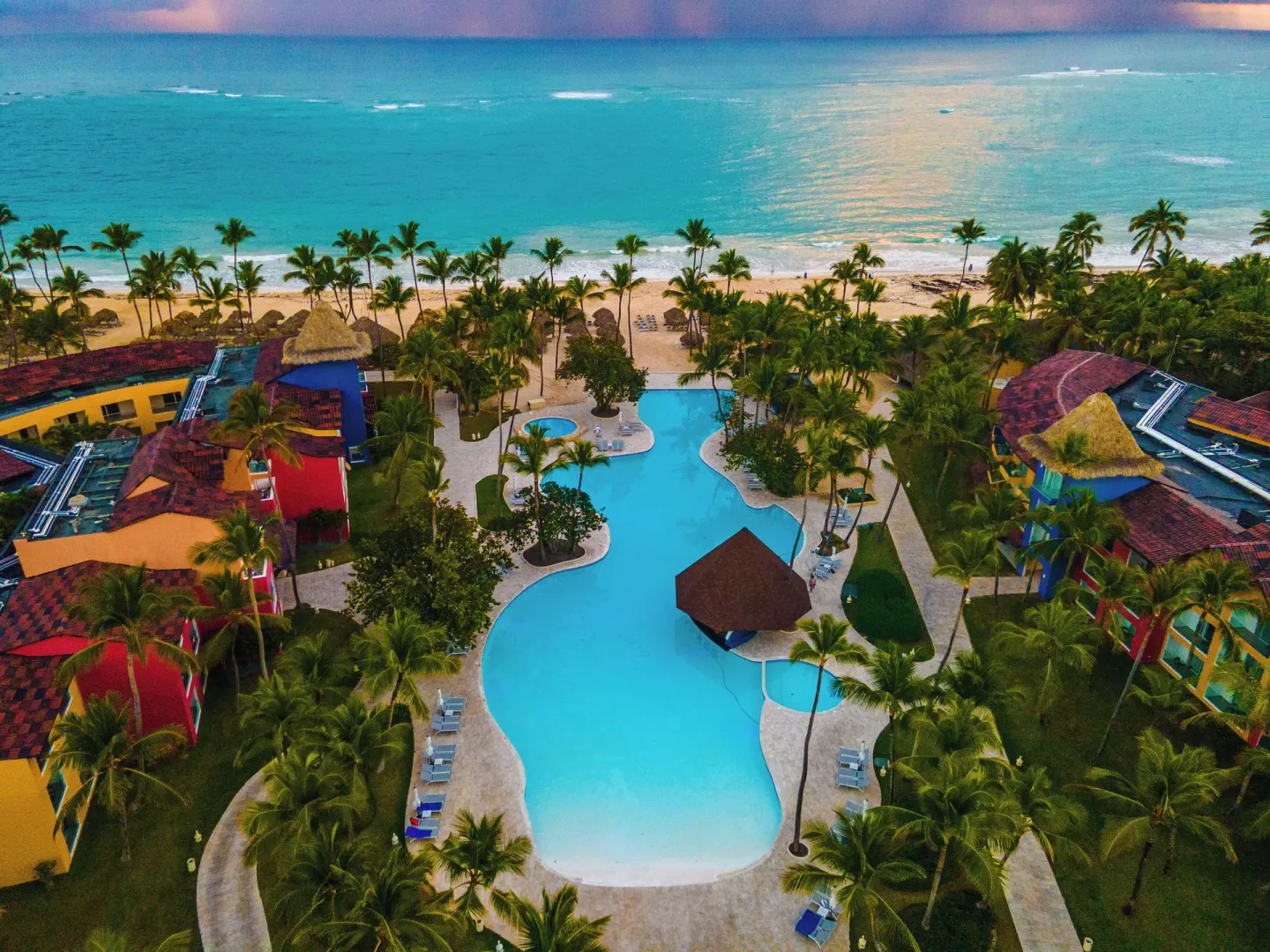 Aerial view of the pool, palms, beach, and ocean at Caribe Deluxe Princess.