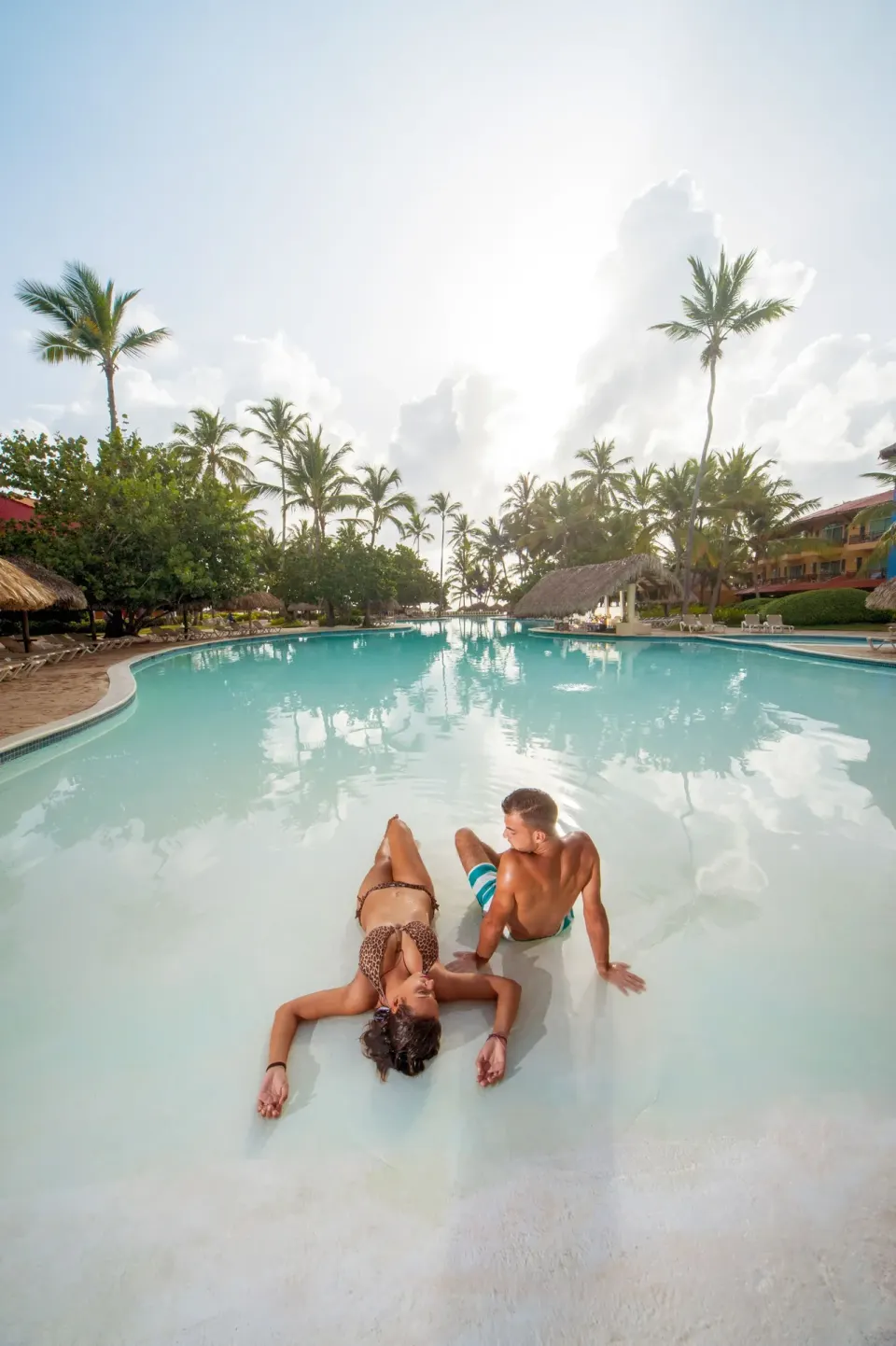 Couple relaxing in the shallow end of a large pool at Caribe Deluxe Princess.