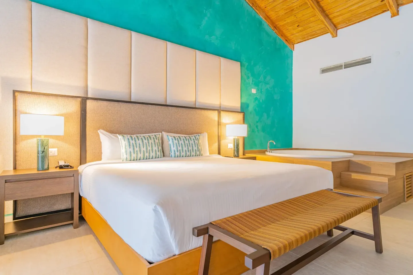 King bed guest room with in-room soaking tub and wood ceiling at Caribe Deluxe Princess.