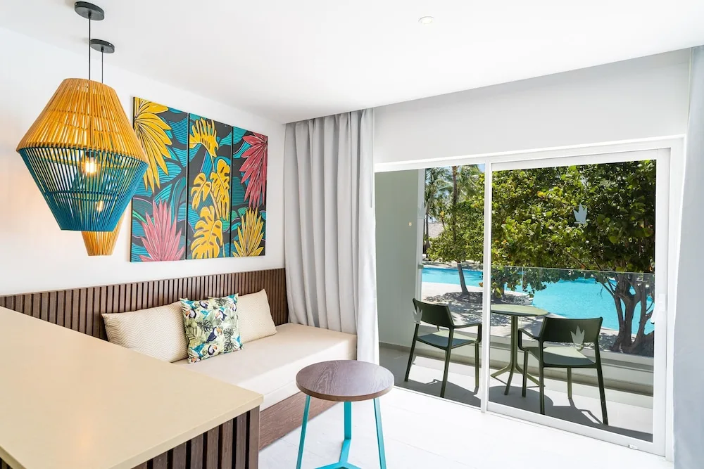 Guest room sitting area with balcony overlooking the pool at Caribe Deluxe Princess.