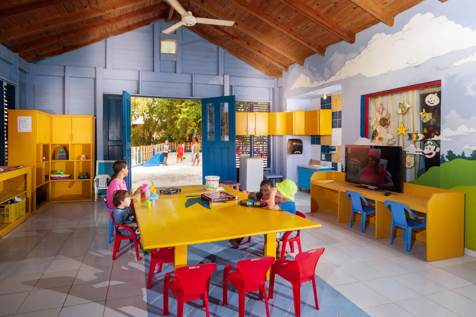 Kids club room with children seated at a yellow table at Caribe Deluxe Princess.