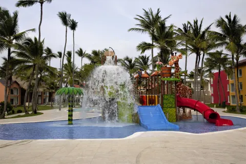 Splash play area with water bucket, slides, and giraffe figure at Caribe Deluxe Princess.