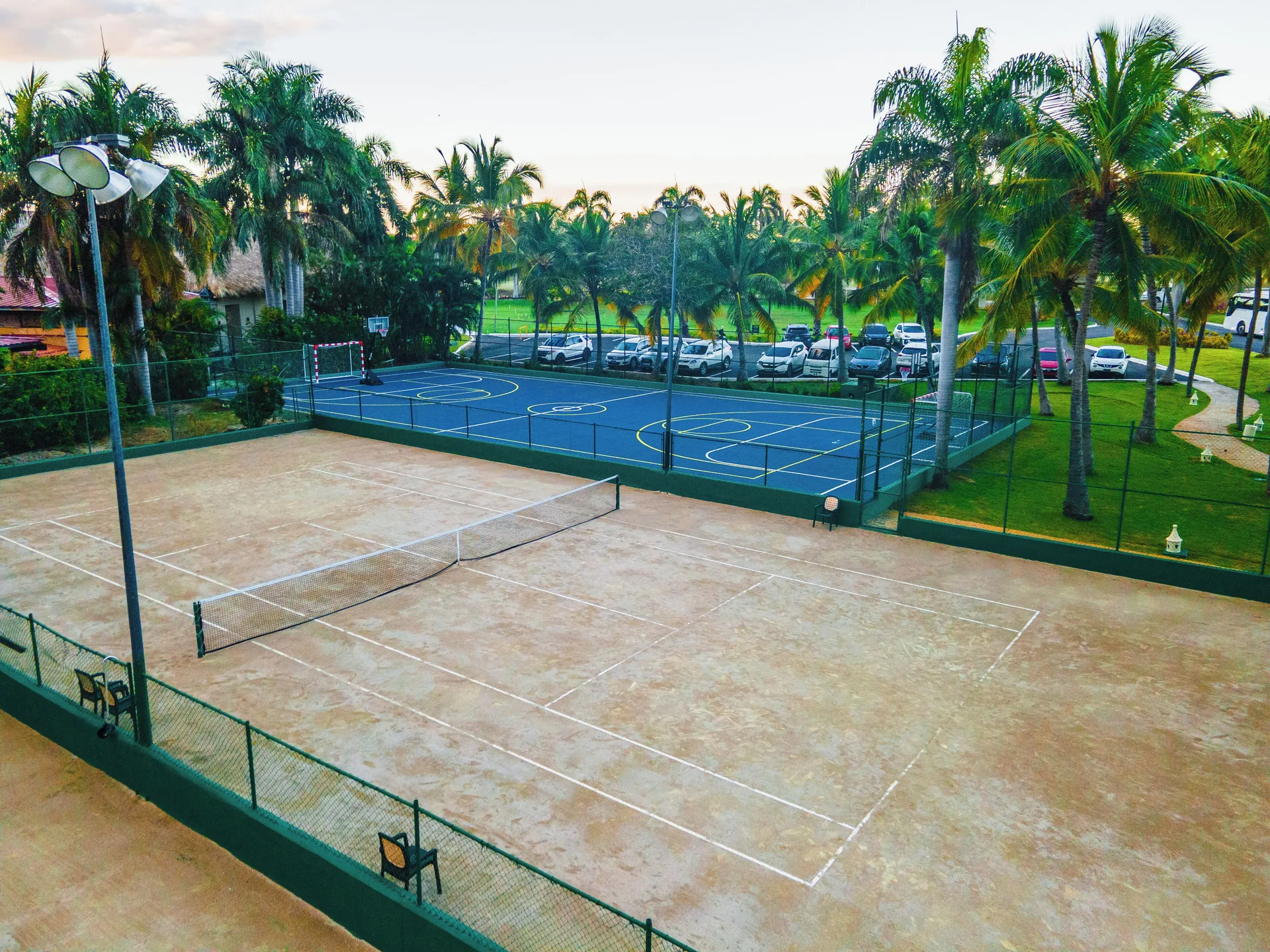 Tennis court and blue sports court among palms at Caribe Deluxe Princess.