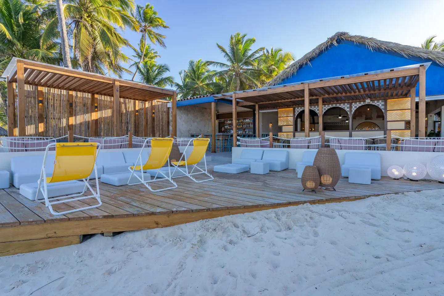 Beachfront lounge deck with yellow chairs at Caribe Deluxe Princess.