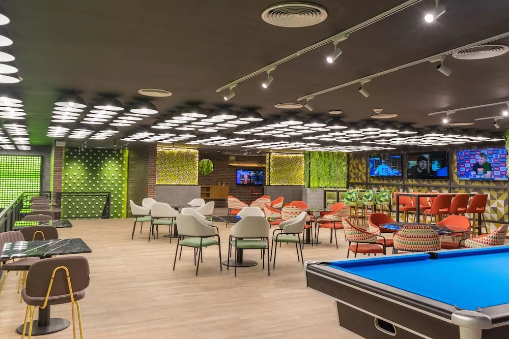 Lounge with pool table, televisions, and patterned seating at Caribe Deluxe Princess.