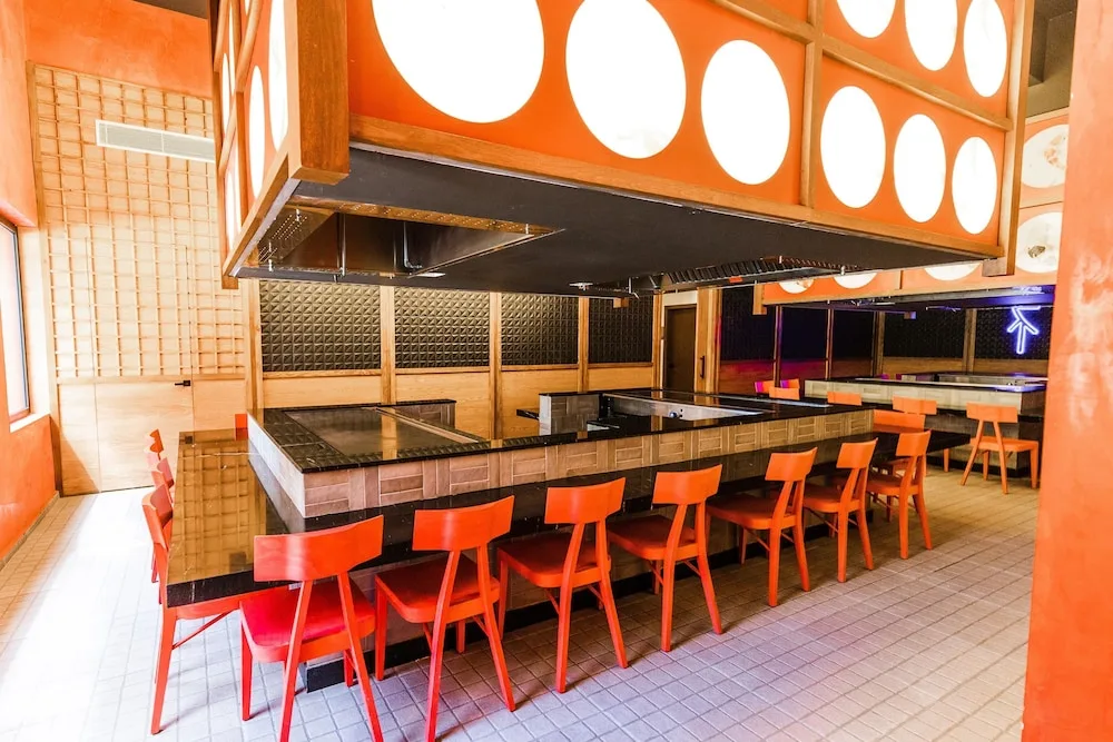 Teppanyaki grill counter with red chairs at Caribe Deluxe Princess.