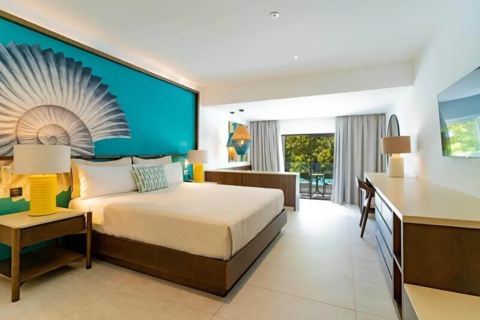 Grand Room king bed, desk and balcony doors at Caribe Deluxe Princess.
