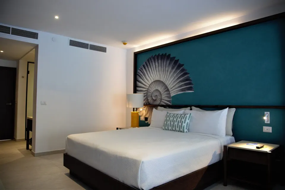Grand Room king bed facing entry area at Caribe Deluxe Princess.