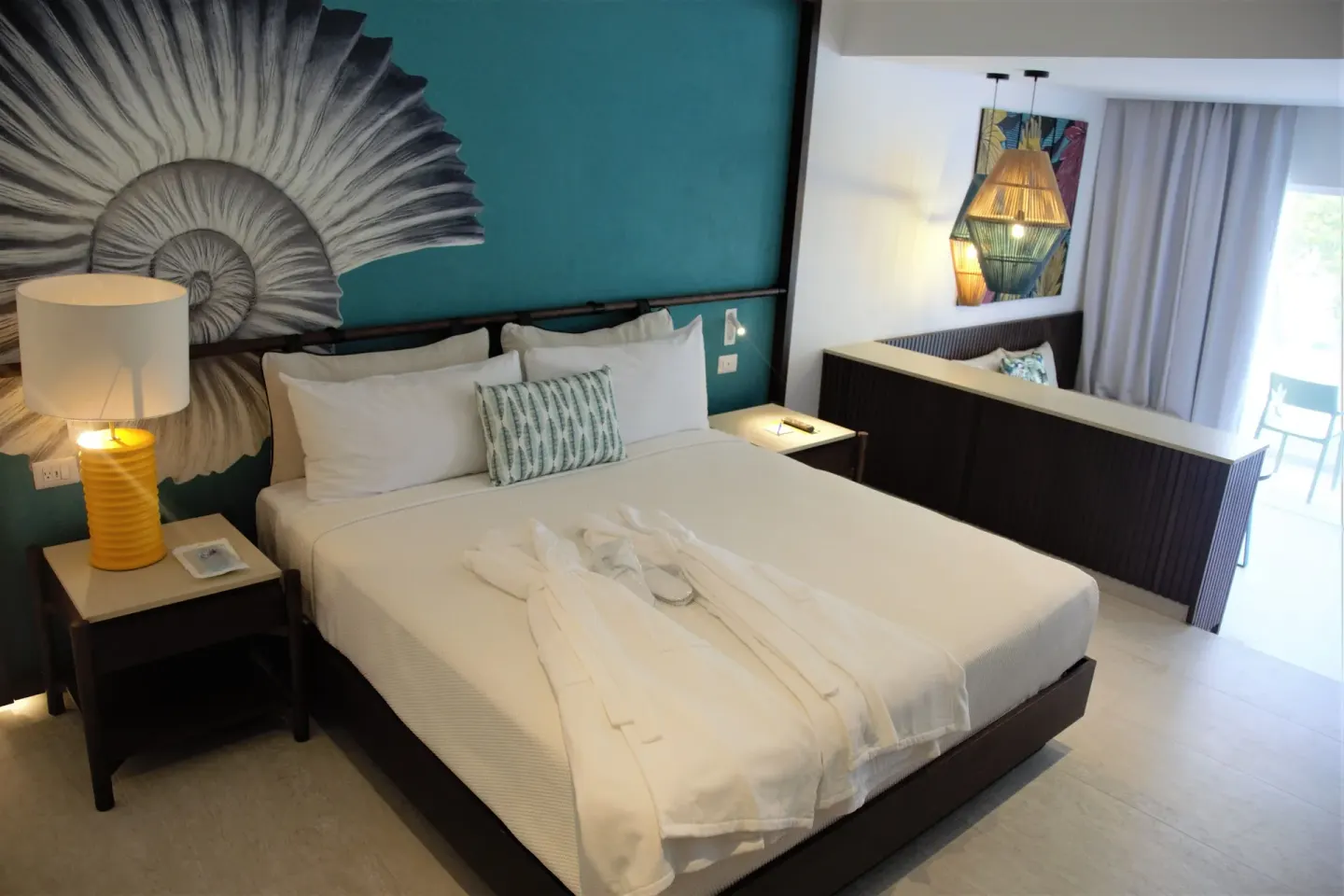Grand Room bed with robes and balcony light at Caribe Deluxe Princess.