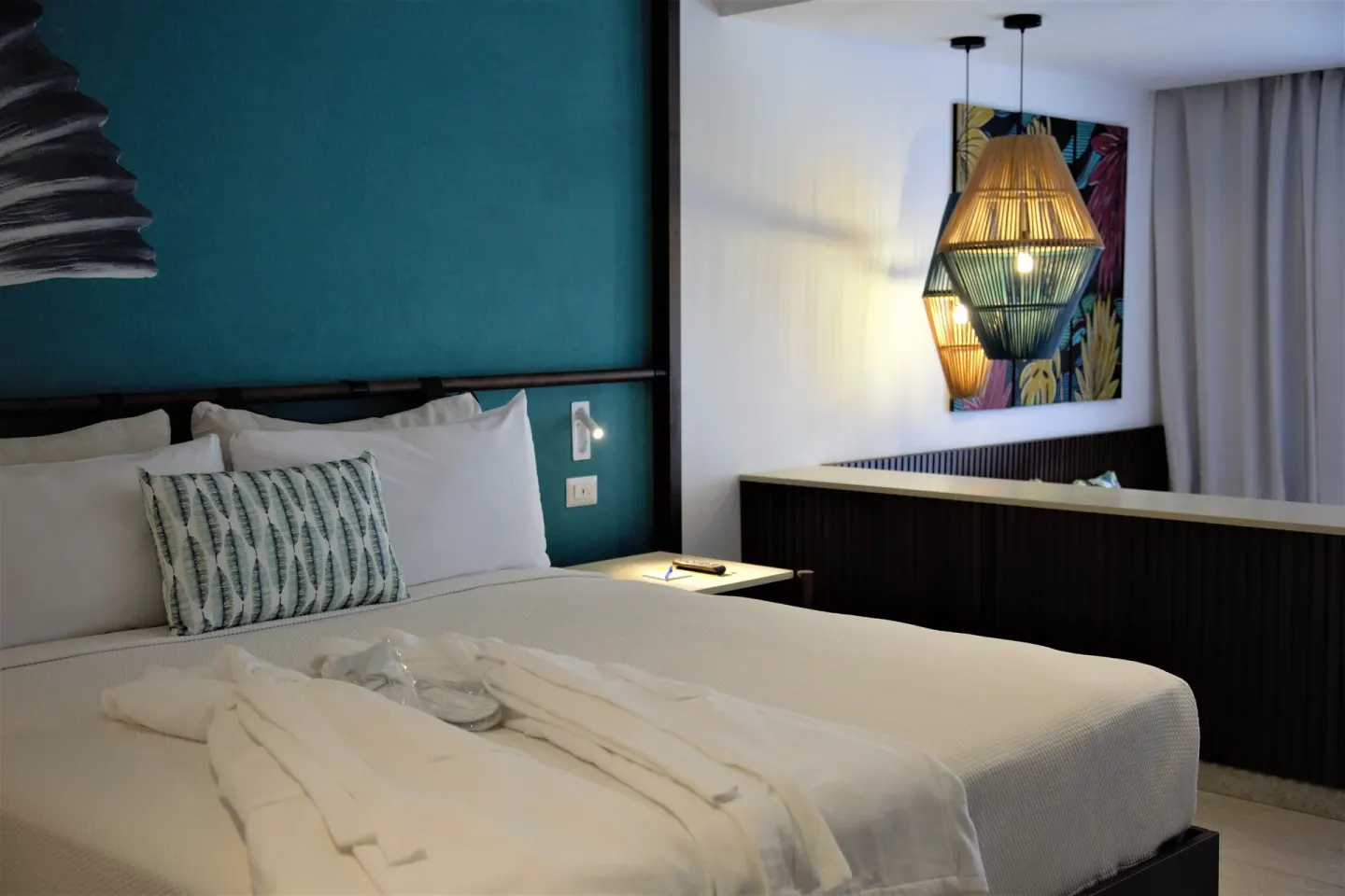 Grand Room bed with robes and pendant lights at Caribe Deluxe Princess.