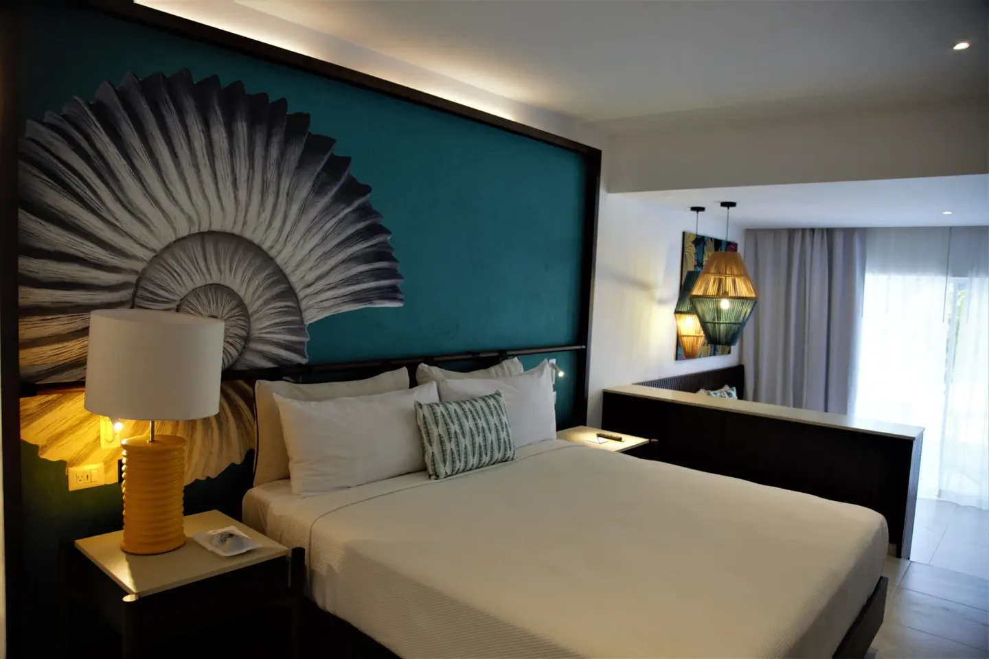 Grand Room king bed with shell wall art at Caribe Deluxe Princess.