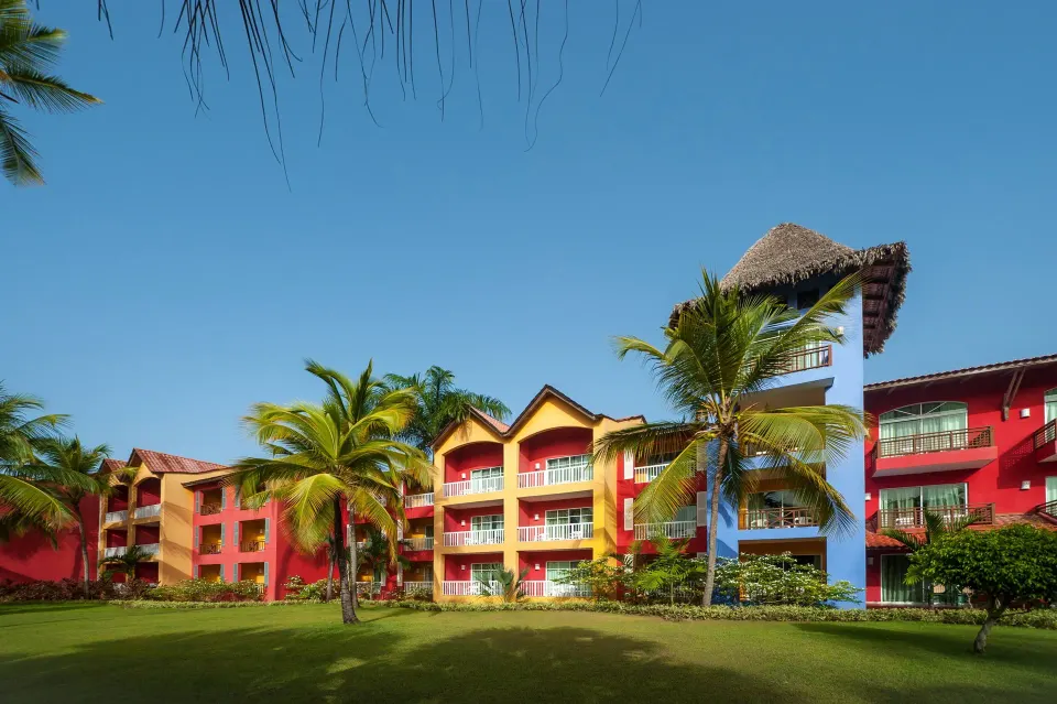 Colorful guest room buildings and palms at Caribe Deluxe Princess.