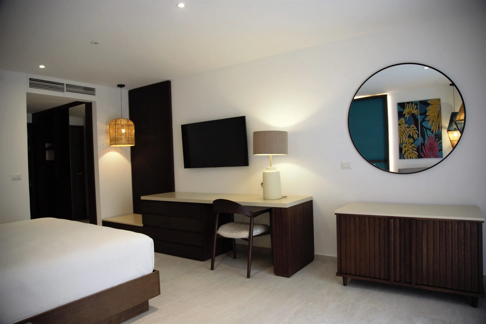 Superior Room with bed, desk, TV and round mirror at Caribe Deluxe Princess.