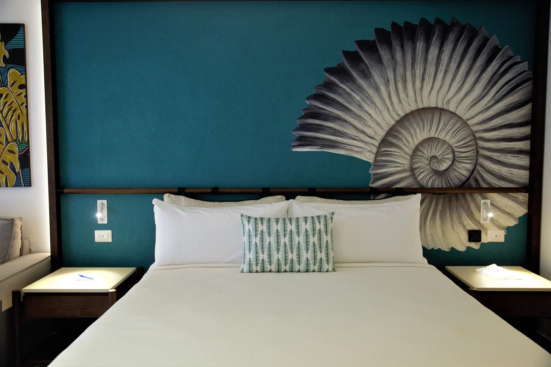 Superior Room king bed with shell mural headboard and lit nightstands at Caribe Deluxe Princess.