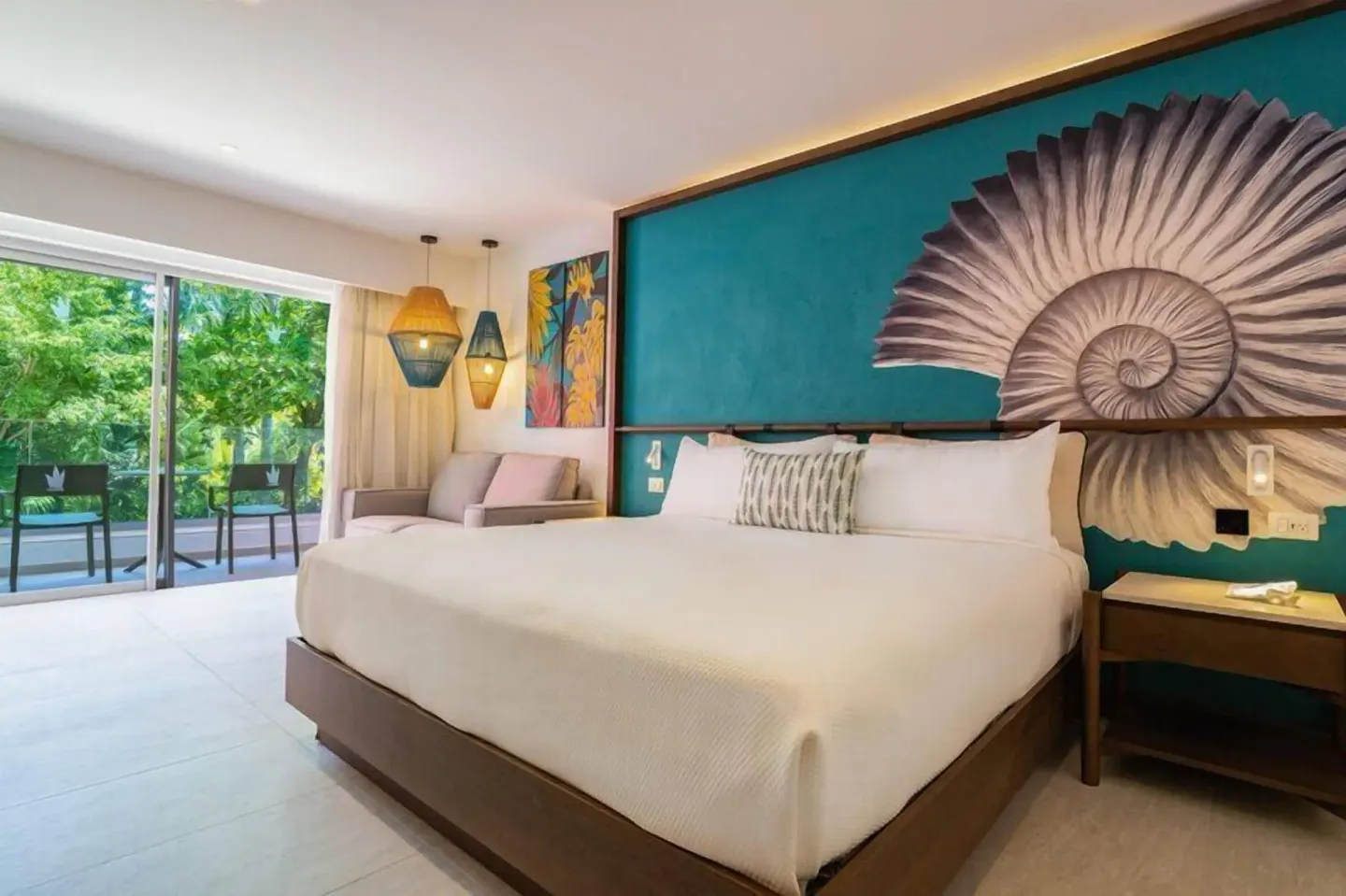 Superior Room king bed with shell mural and balcony at Caribe Deluxe Princess.