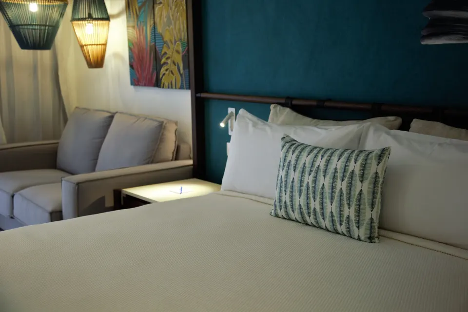 Superior Room bed and sofa nook with pendant lights at Caribe Deluxe Princess.