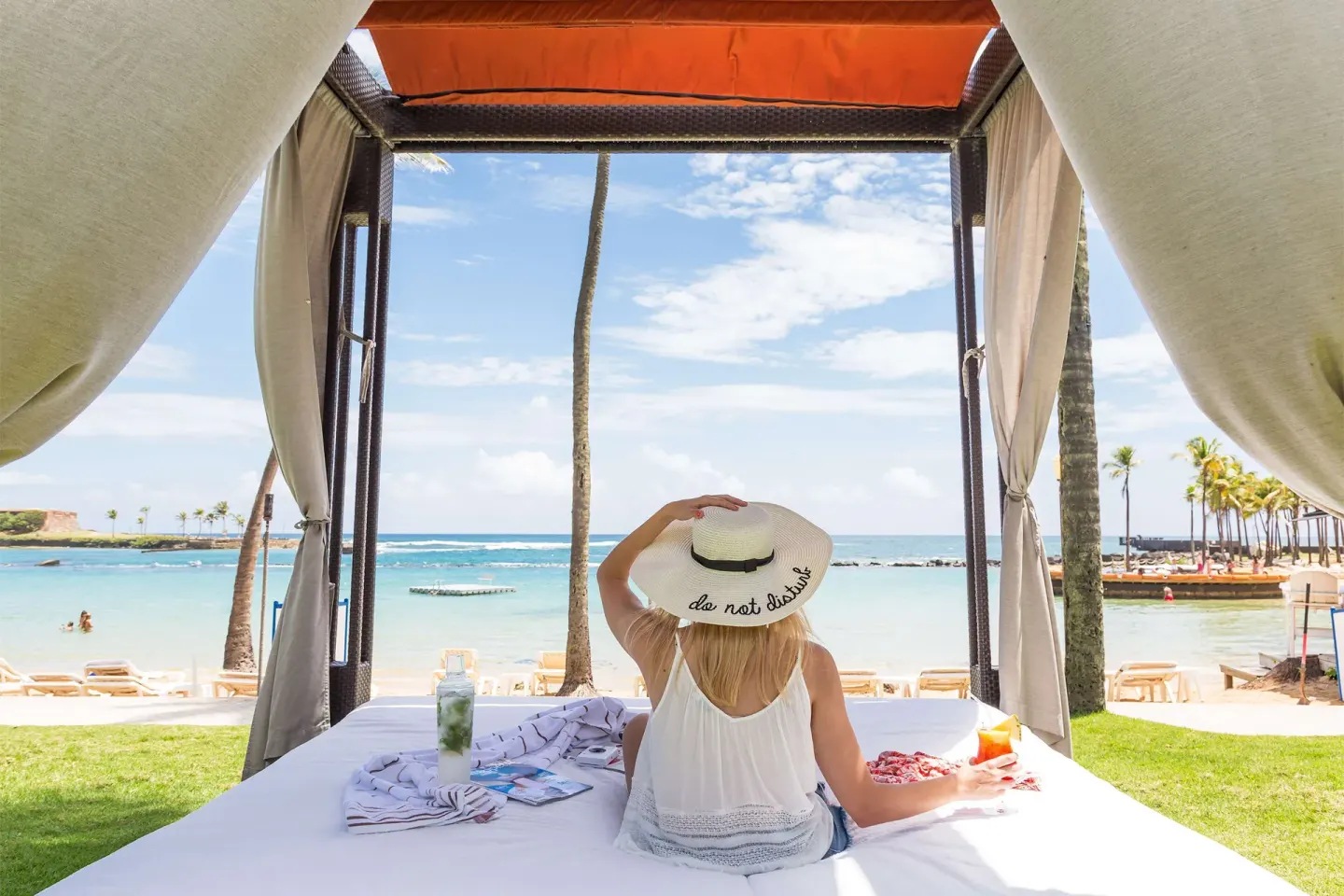 Beach cabana daybed facing the lagoon and ocean at Caribe Hilton.