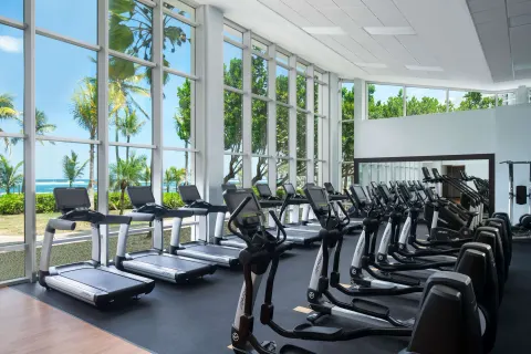 Fitness center with cardio machines and ocean-facing windows at Caribe Hilton.