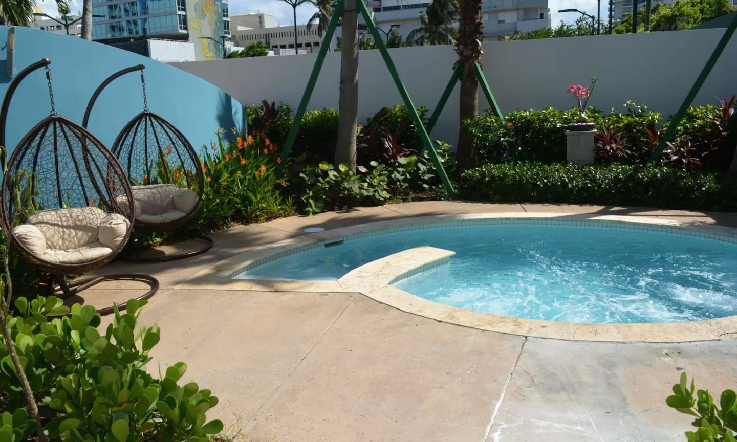 Small spa pool with hanging chairs in a garden at Caribe Hilton.