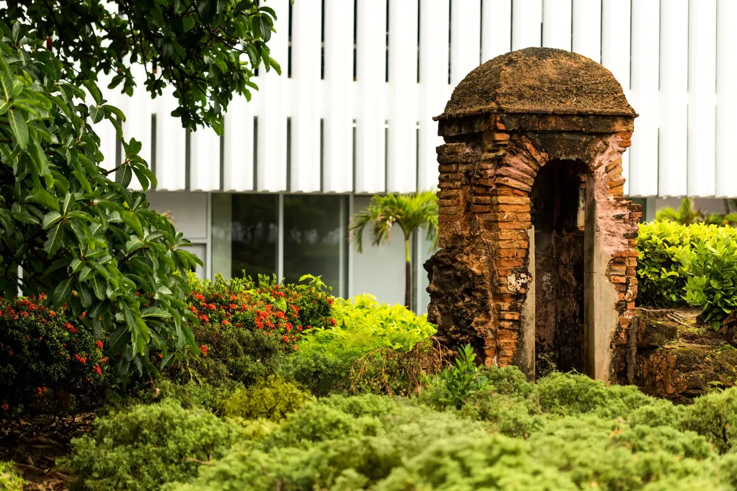 Historic brick garden structure surrounded by greenery at Caribe Hilton.