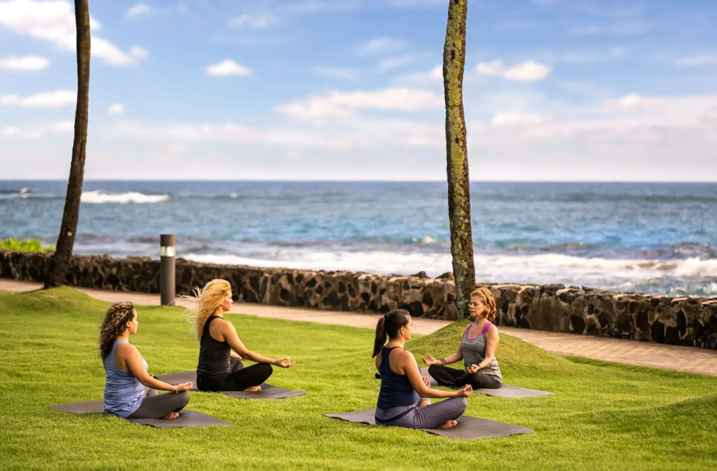 Outdoor yoga class on the lawn beside the ocean at Caribe Hilton.