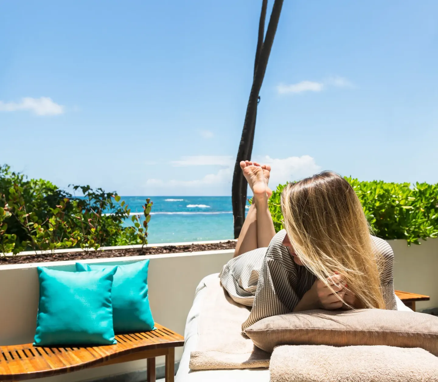 Guest relaxing on an outdoor spa lounger with ocean view at Caribe Hilton.