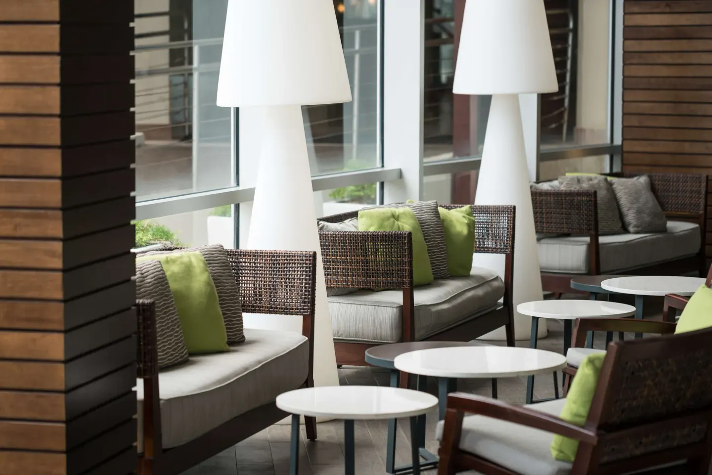 Wicker lounge seating with green pillows and white floor lamps at Caribe Hilton.