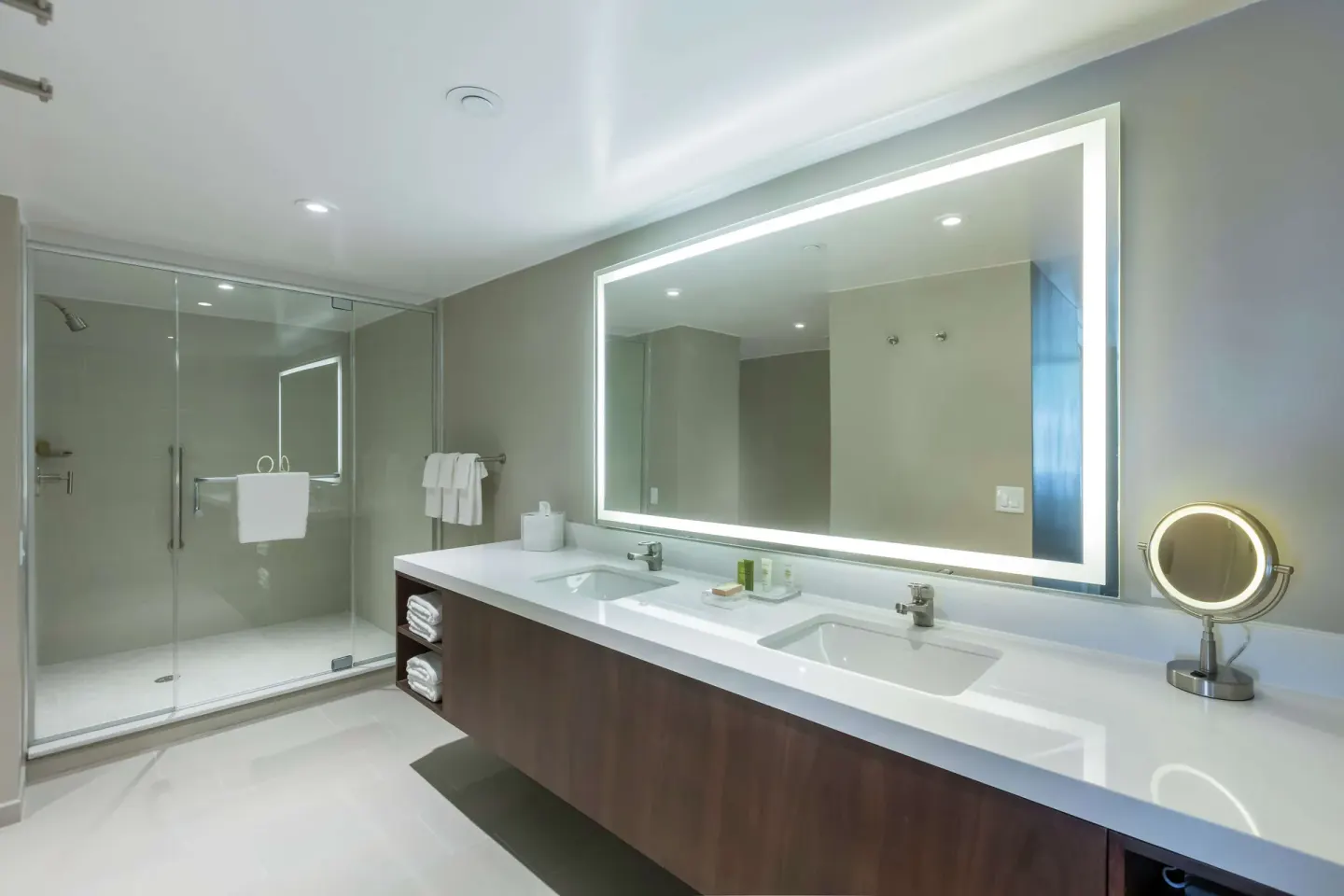 Bathroom in a two-bedroom bi-level suite at Caribe Hilton with double vanity and glass shower.